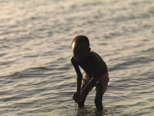 El molo tribe kid drinking in the lake, Turkana lake, Loiyangalani, Kenya