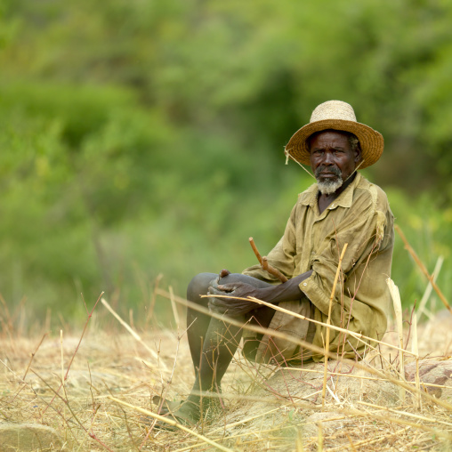 Tharaka old man with a hat sit in the bush, Laikipia County, Mount Kenya, Kenya