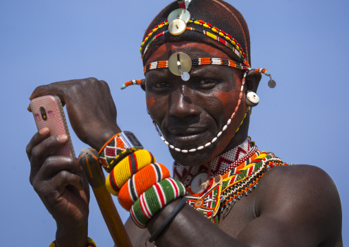 Rendille tribesman taking picture with his mobile phone, Turkana lake, Loiyangalani, Kenya