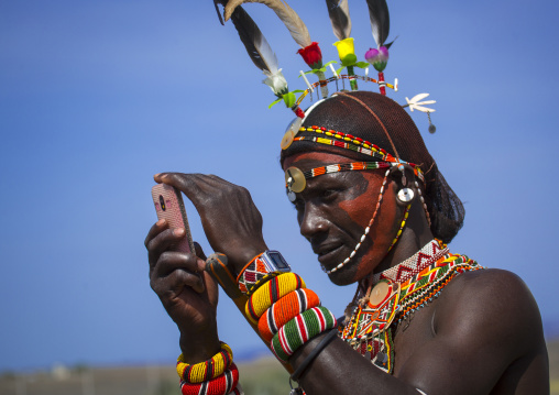 Rendille tribesman taking picture with his mobile phone, Turkana lake, Loiyangalani, Kenya