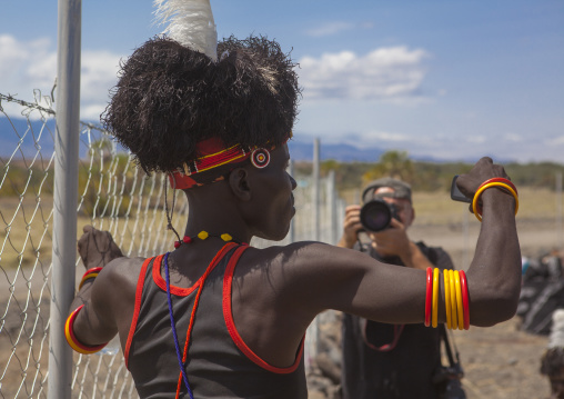 Turkana tribesman taking pictures in front of tourists, Turkana lake, Loiyangalani, Kenya