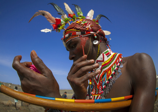 Rendille tribesman applying make up, Turkana lake, Loiyangalani, Kenya