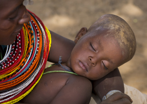 Rendille tribeswoman holding her sleeping baby, Marsabit district, Ngurunit, Kenya