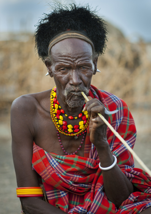 Turkana tribesman using a big toothbrush, Turkana lake, Loiyangalani, Kenya