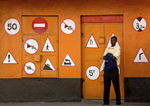 Kenyan man standing in front of a driving school, Rift Valley Province, Lake Nakuru, Kenya