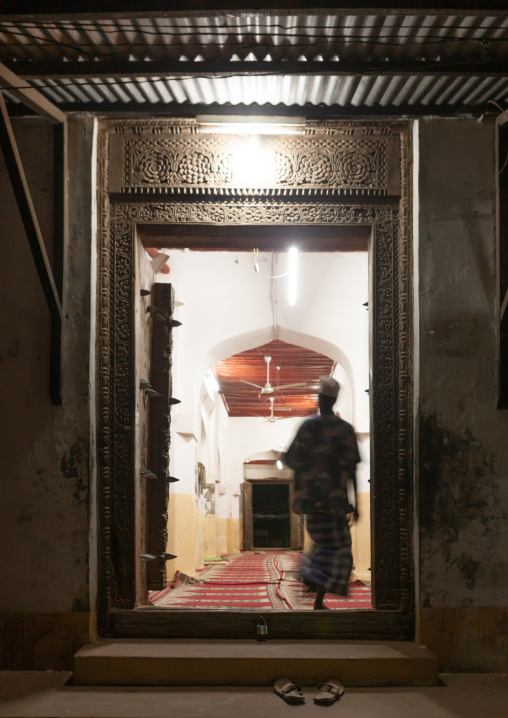 Muslim man entering a mosque at night, Lamu County, Lamu, Kenya