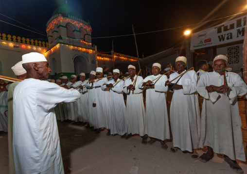 Muslim men singing and dancing with goma sticks during Maulid festival, Lamu County, Lamu, Kenya