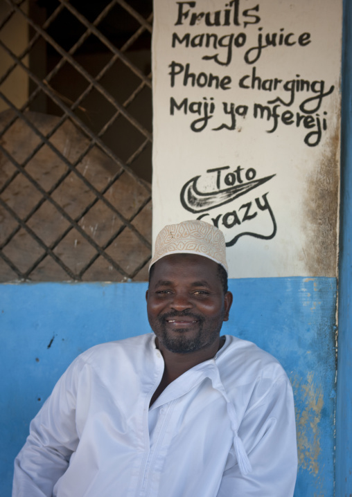 Smiling muslim man sittting in front of a shop, Lamu County, Lamu, Kenya