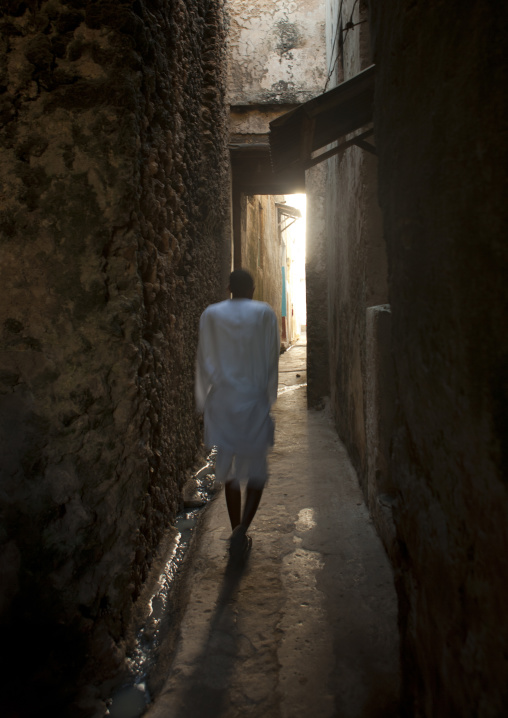 Muslim man walking in a narrow street, Lamu County, Lamu, Kenya