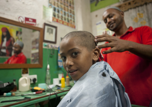 Young boy getting head shaved in barbershop, Lamu County, Lamu, Kenya