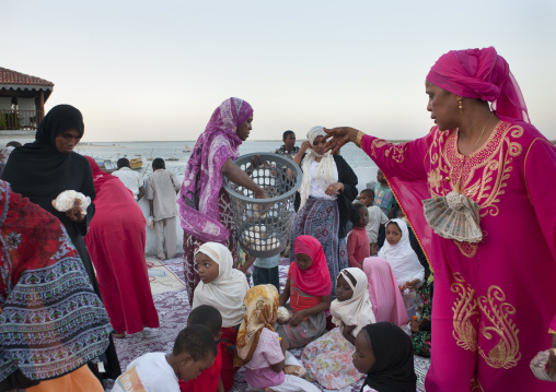 Muslim woman giving food during Maulid festival, Lamu County, Lamu, Kenya