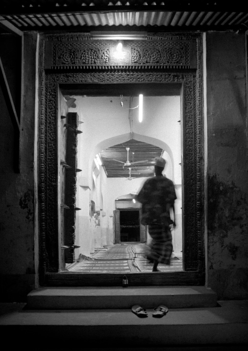 Muslim man entering a mosque at night, Lamu County, Lamu, Kenya