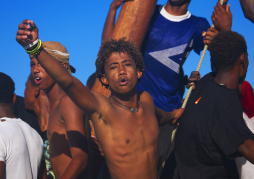 Young boy raising punch on boat, Lamu County, Lamu, Kenya
