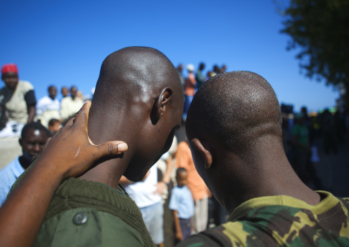 Two policemen holding each other in the street, Lamu County, Lamu, Kenya