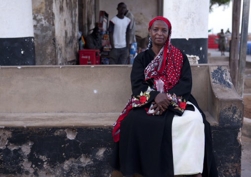 A muslim woman sitting on a concrete bench, Lamu County, Lamu, Kenya