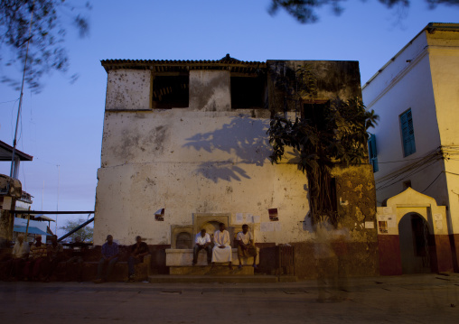 Men standing on the fountain at night, Lamu County, Lamu, Kenya