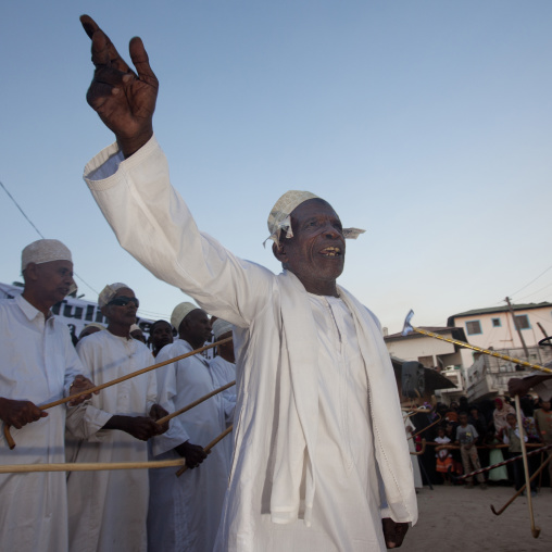 Muslim men singing and dancing with goma sticks during Maulid festival, Lamu County, Lamu, Kenya