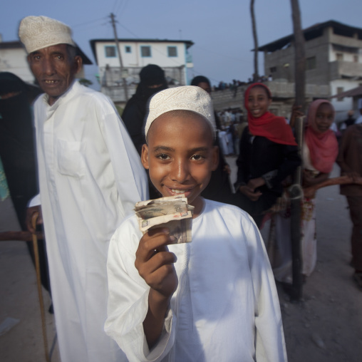 Young muslim boy with bank notes he received during Maulid festival, Lamu County, Lamu, Kenya