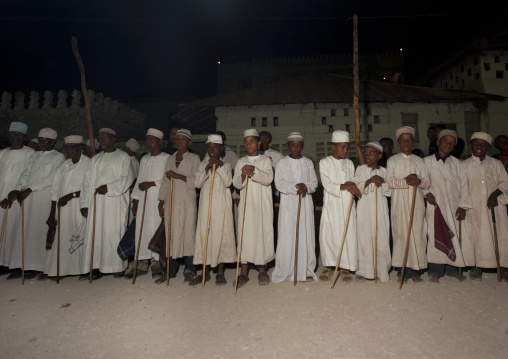 Muslim men singing and dancing with goma sticks during Maulid festival, Lamu County, Lamu, Kenya