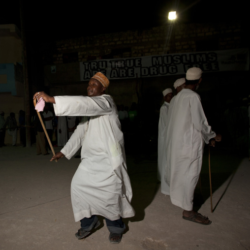 Muslim men singing and dancing with goma sticks during Maulid festival, Lamu County, Lamu, Kenya