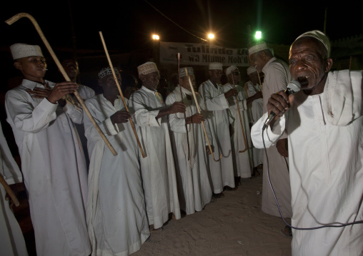 Muslim men singing and dancing with goma sticks during Maulid festival, Lamu County, Lamu, Kenya