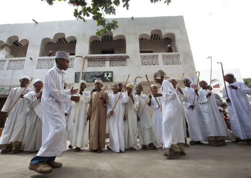 Muslim men singing and dancing with goma sticks during Maulid festival, Lamu County, Lamu, Kenya