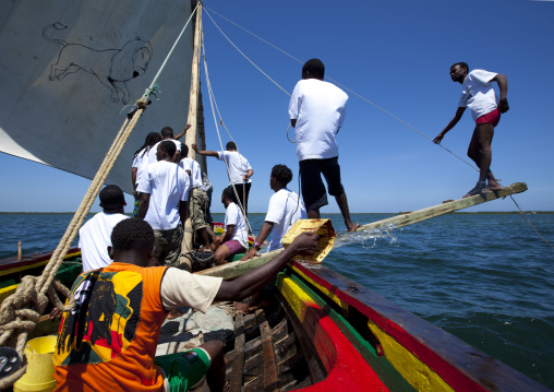 Men balancing dhow while sailing during the Maulid festival race, Lamu County, Lamu, Kenya