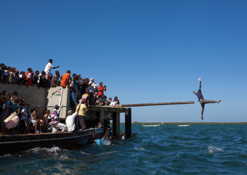 Men trying to keep balance for a competition during Maulid festival, Lamu County, Lamu, Kenya