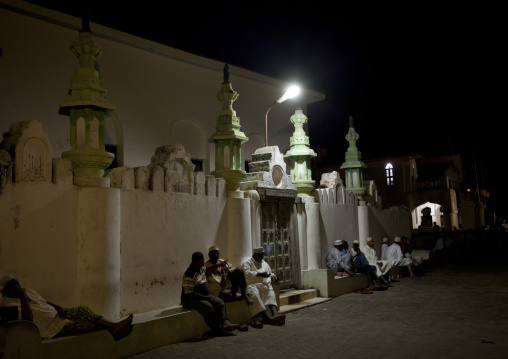 Men sitting outside a mosque at night during Maulid festival, Lamu County, Lamu, Kenya