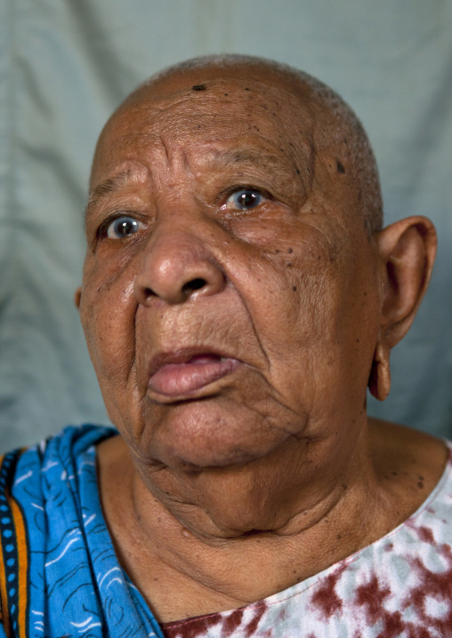 Portrait of a senior woman with shaved head and enlarged earlobes, Lamu County, Siyu, Kenya