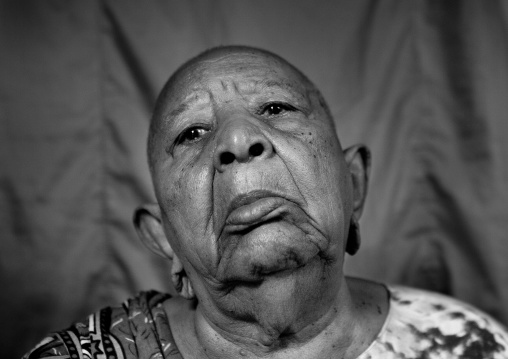 Portrait of a senior woman with shaved head and enlarged earlobes, Lamu County, Siyu, Kenya