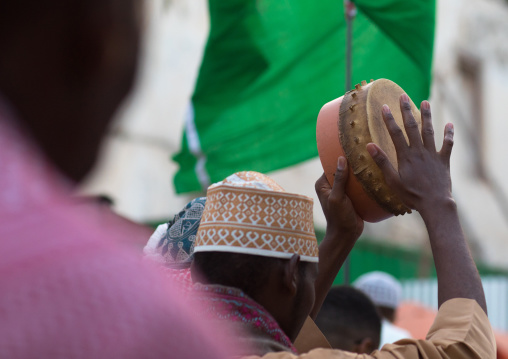 Sunni muslim men playing tambourines during the maulidi festivities in the street, Lamu county, Lamu town, Kenya