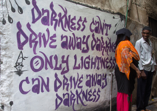 Mulsim people speaking in front of a wall covered with graffitis, Lamu county, Lamu town, Kenya