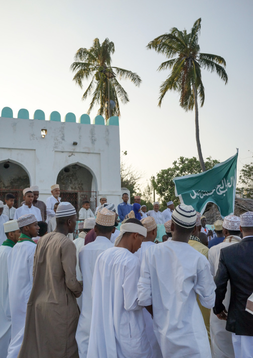 Sunni muslim people parading with flags during the maulidi festivities in the street, Lamu county, Lamu town, Kenya