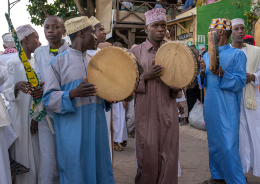 Sunni muslim men playing tambourines during the maulidi festivities in the street, Lamu county, Lamu town, Kenya