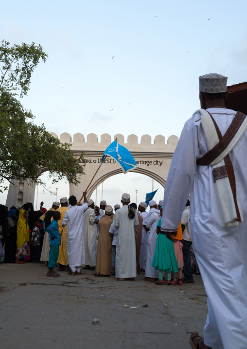 Sunni muslim people parading in front of the town gate during the maulidi festivities in the street, Lamu county, Lamu town, Kenya