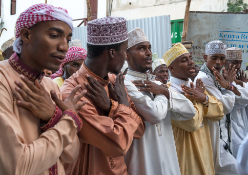 Sunni muslim men dancing during the maulidi festivities in the street, Lamu county, Lamu town, Kenya