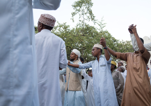 Sunni muslim men dancing during the maulidi festivities in the street, Lamu county, Lamu town, Kenya