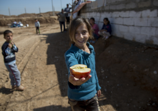 A Young Syrian Refugee Girl Sharing An Apple, Qushtapa Refugee Camp, Erbil, Kurdistan, Iraq