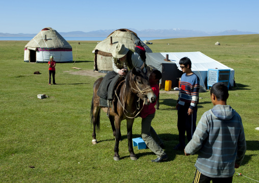 Man Helping A Bbc Reporter To Get On His Horse, Jaman Echki Jailoo Village, Song Kol Lake Area, Kyrgyzstan