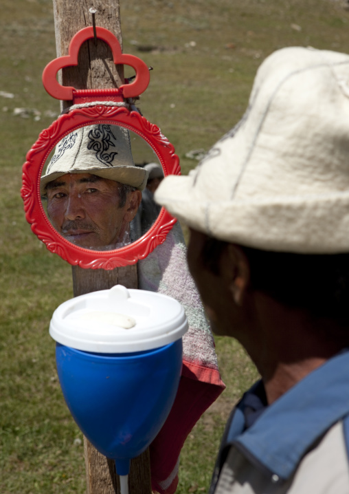Man With Kalpak Hat Looking At Himself In A Mirror, Song Kol Lake Area, Kyrgyzstan