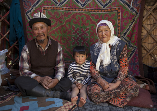 Old Couple Sitting With A Young Boy In Their Yurt, Kyzart River, Kyrgyzstan