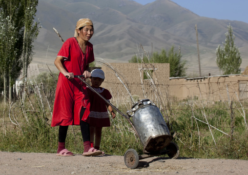 Mother And Child Pushing A Big Milk Jug On Casters, Kochkor, Kyrgyzstan