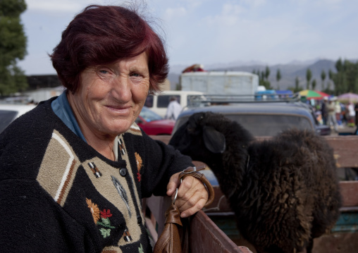 Old Woman With A Sheep In The Storage Compartment Of Her Truck, Kochkor Animal Market, Kyrgyzstan