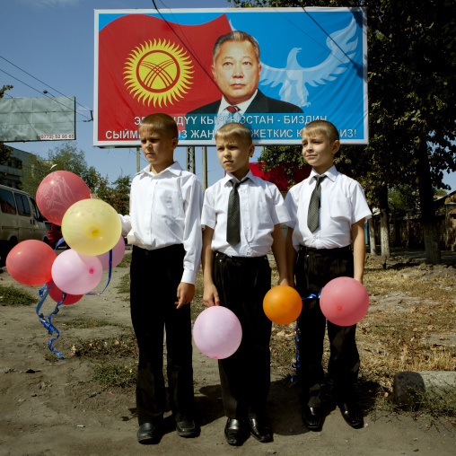 Boys In Suit Holding Balloons In Front Of  A Propaganda Billboard, Bishkek, Kyrgyztan