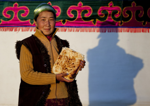 Woman Holding Bread In Front Of A Yurt In Jaman Echki Jailoo Village, Song Kol Lake Area, Kyrgyzstan