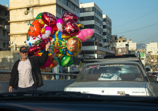 Syrian refugee man selling balloons in the street during traffic jam, Beirut Governorate, Beirut, Lebanon