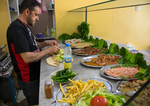 Lebanese man cooking fish in a local restaurant, North Governorate, Tripoli, Lebanon