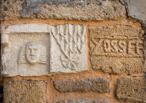 Carved stone at the entrance of a house decpicting the name and the face of the owner, South Governorate, Tyre, Lebanon