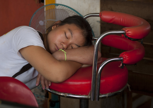 Woman sleeping on a chair, Pakse, Laos